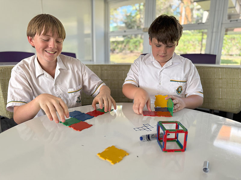 Students use snap-together plastic blocks and plates to build 3D shapes