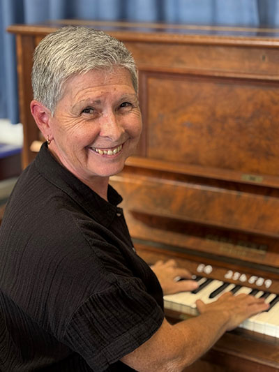 Mrs Mac sitting at a piano