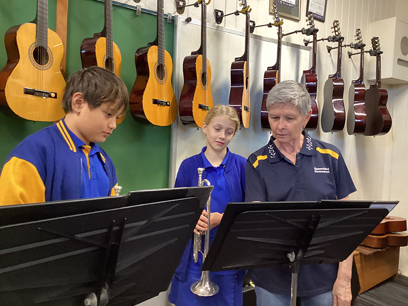 Mrs Mac teaching students trumpet