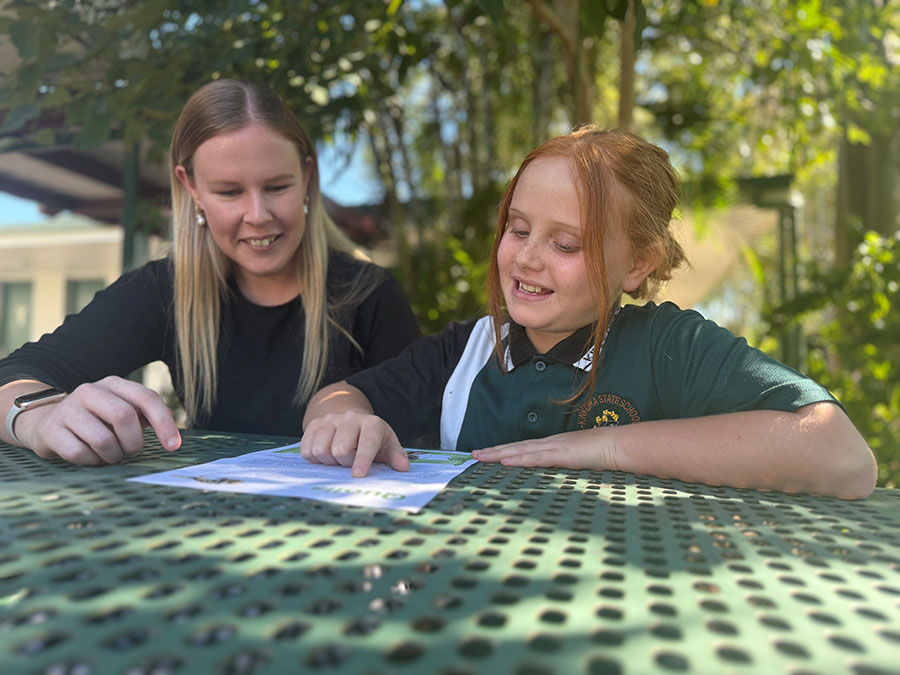 Teacher and student sitting at a table reading